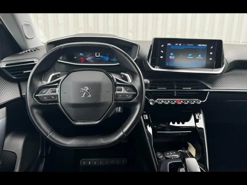 Vue intérieure du tableau de bord et volant noir multifonction du Peugeot 2008 2020 avec écran tactile et finitions carbone.
