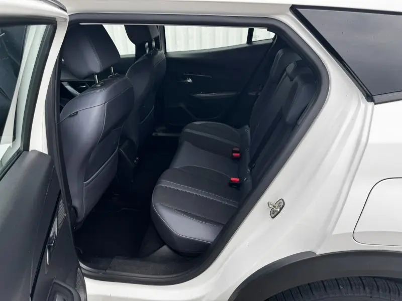Intérieur arrière du Peugeot 2008 blanc banquise, vue côté gauche avec sièges arrière en tissu et cuir noir.