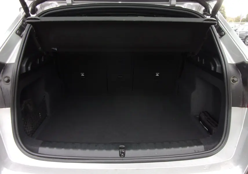 Coffre ouvert vu de l'arrière d'un BMW X1 argent métallisé 2024, montrant un espace de chargement propre et spacieux.