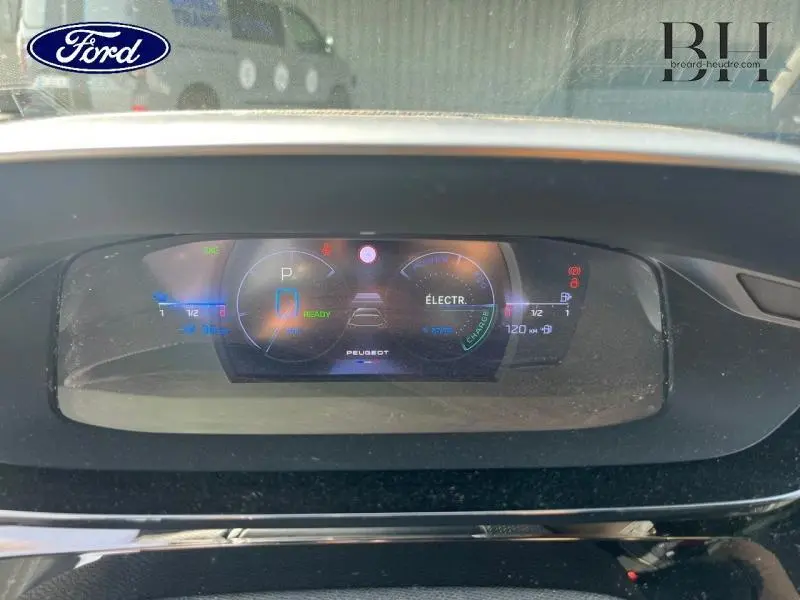 Affichage numérique du tableau de bord du Peugeot 308 SW PHEV blanc, montrant l'état électrique et la vitesse.