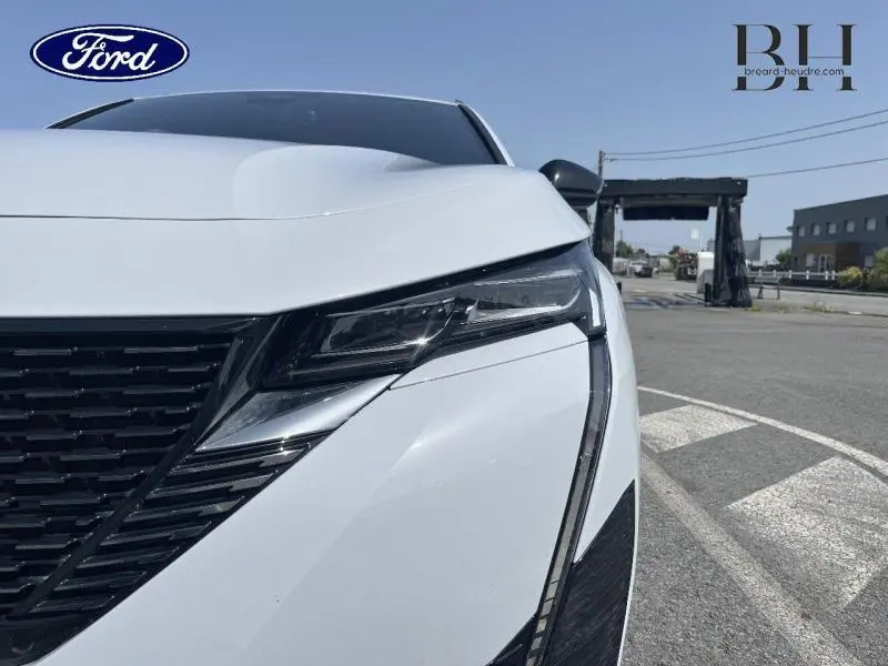 Gros plan sur le phare avant droit blanc Okénite d'une Peugeot 308 SW PHEV 180ch GT e-EAT8 2023.