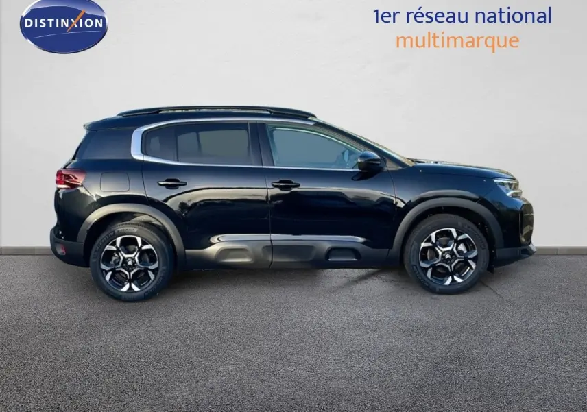 Profil côté gauche d'un Citroën C5 Aircross noir Perla Metal avec jantes alliage et barres de toit visibles.
