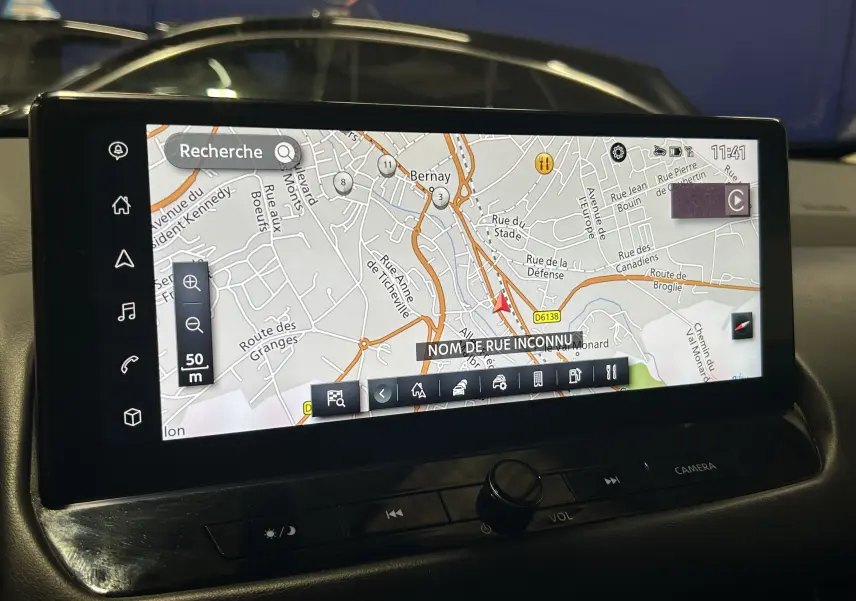 Écran tactile du GPS du Nissan Qashqai 1.3 Hybrid 2023, affichant une carte routière en intérieur véhicule.