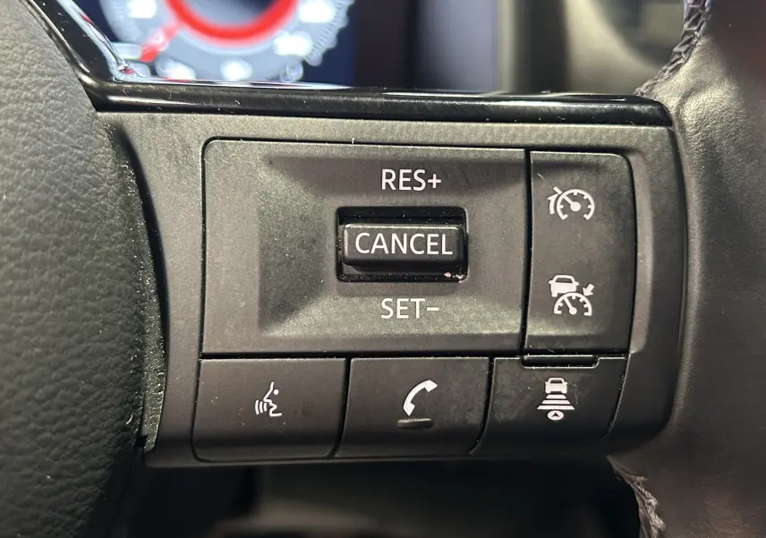 Gros plan sur les boutons de commande au volant côté droit du Nissan Qashqai blanc lunaire 2023.