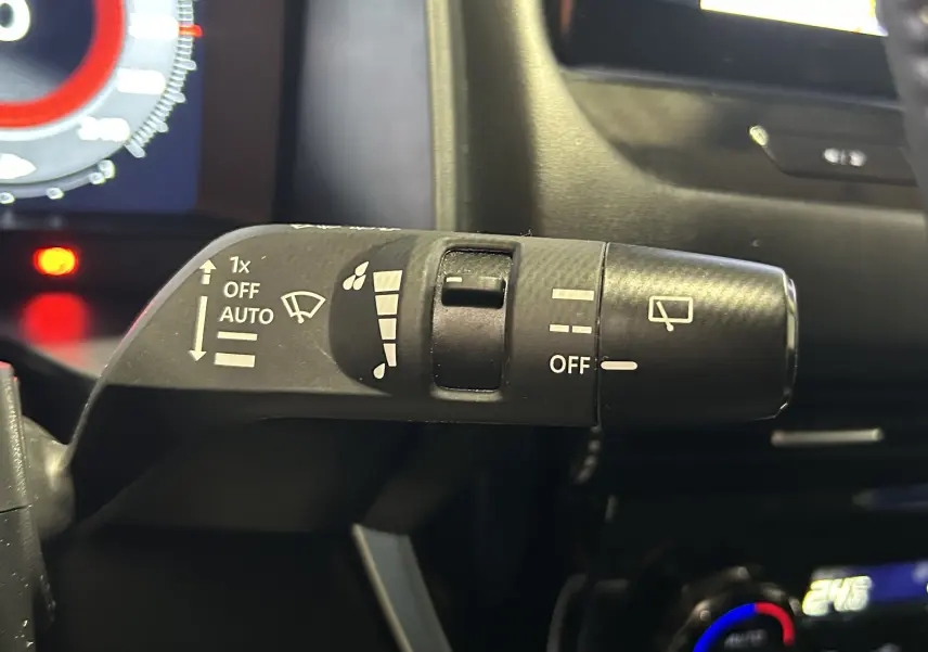 Gros plan sur la commande d’essuie-glace du Nissan Qashqai blanc lunaire 2023, côté gauche du volant.