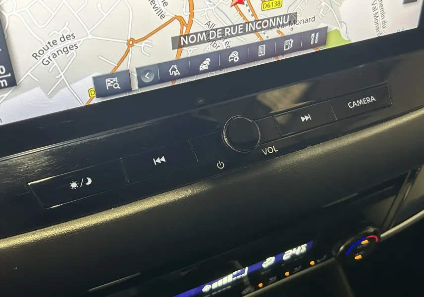 Vue rapprochée du tableau de bord du Nissan Qashqai blanc lunaire 2023, mettant en valeur l’écran tactile et les commandes caméra.