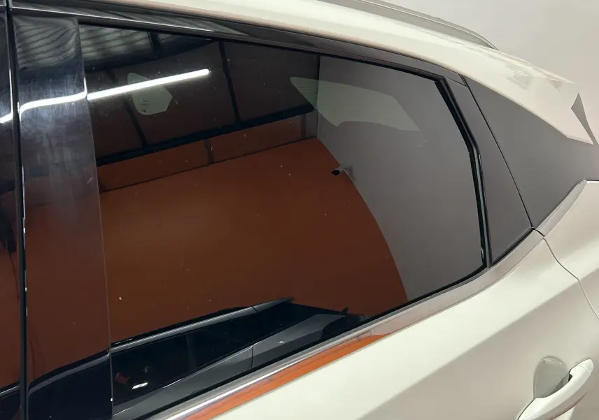 Vue latérale droite du Nissan Qashqai blanc lunaire, mettant en valeur la vitre arrière teintée et la poignée de porte.