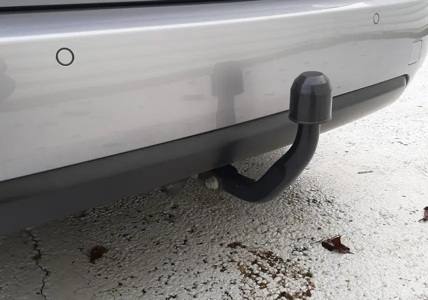 Gros plan sur l'attelage noir fixé au pare-chocs arrière gris Artense du Peugeot 308 SW 2021.