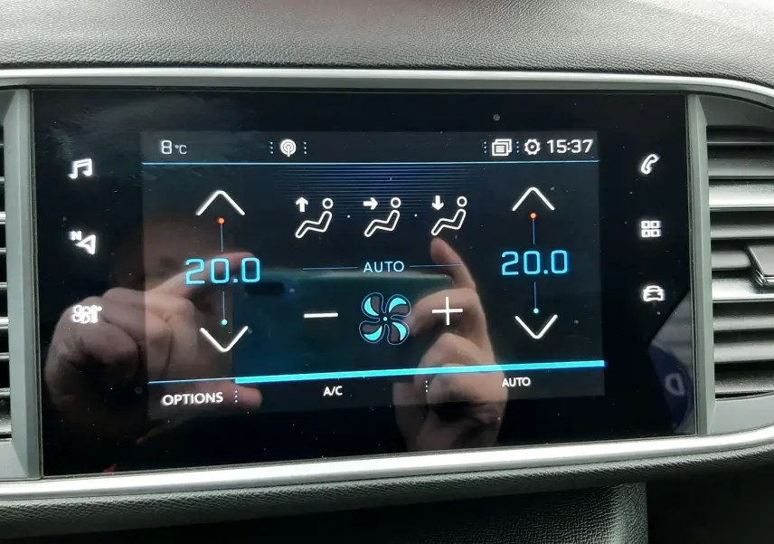 Écran tactile de climatisation automatique affichant 20°C côté gauche et droit dans un Peugeot 308 SW gris Artense.