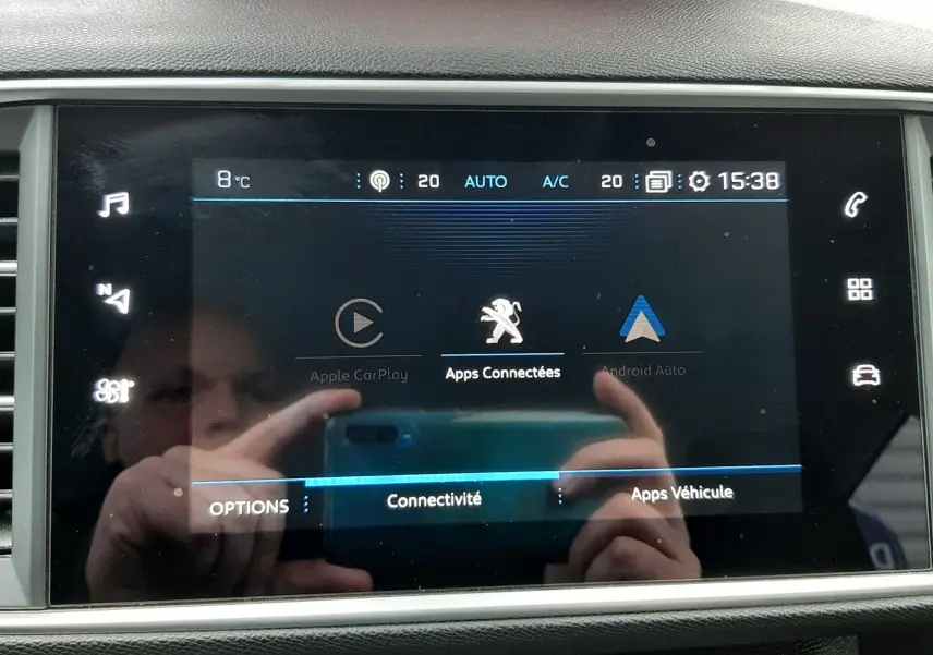 Écran tactile central du tableau de bord du Peugeot 308 SW gris Artense, affichant les options de connectivité et applications.