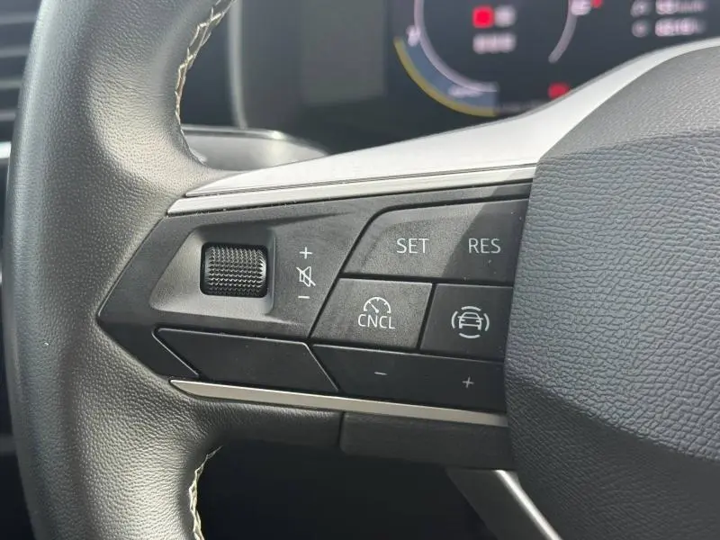 Gros plan sur les commandes multifonctions du volant cuir du SEAT LEON 2.0 TDI 115ch STYLE XL 2025 en blanc Nevada.