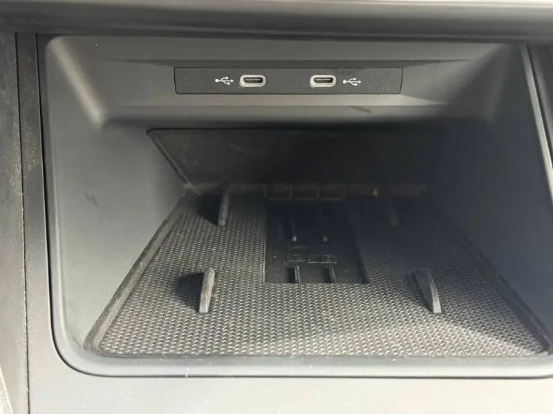 Gros plan sur la console centrale du SEAT LEON 2025, montrant deux ports USB-C et un espace de rangement noir texturé.
