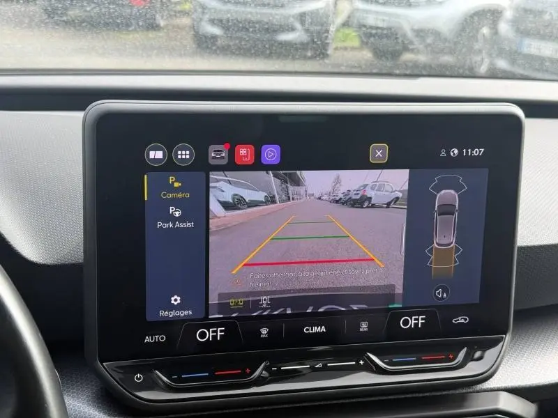 Écran tactile intérieur montrant la caméra de recul et l’aide au stationnement d’une SEAT Leon blanche.