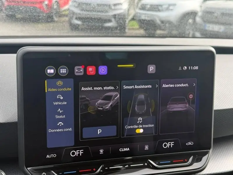 Écran tactile central du tableau de bord du SEAT Leon blanc, affichant les aides à la conduite en vue frontale.