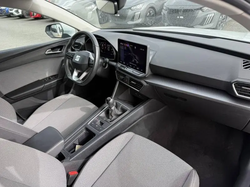 Vue intérieure côté conducteur du SEAT Leon 2025, montrant le volant cuir multifonction et l’écran tactile central.