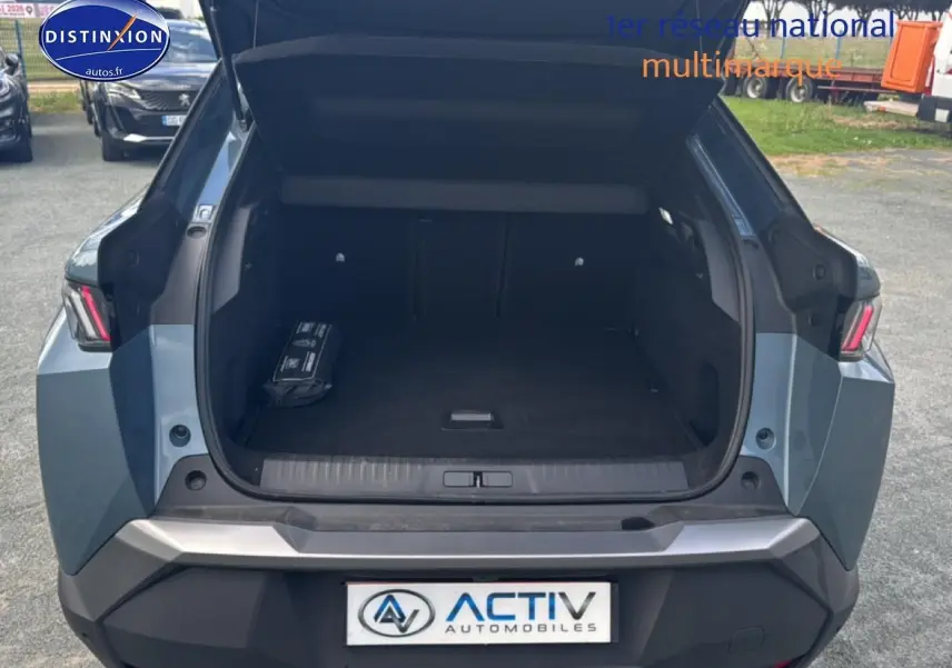 Vue arrière du coffre ouvert d'un Peugeot 3008 bleu 2025, mettant en valeur l'espace de chargement vide.