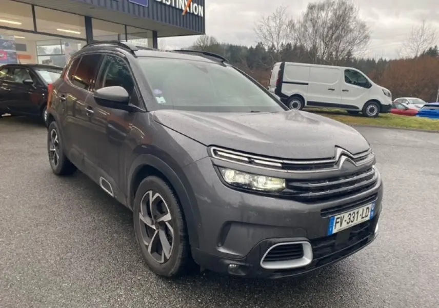 Citroën C5 Aircross gris platinium en 3/4 avant droit, avec jantes alliage 18 pouces et feux allumés.