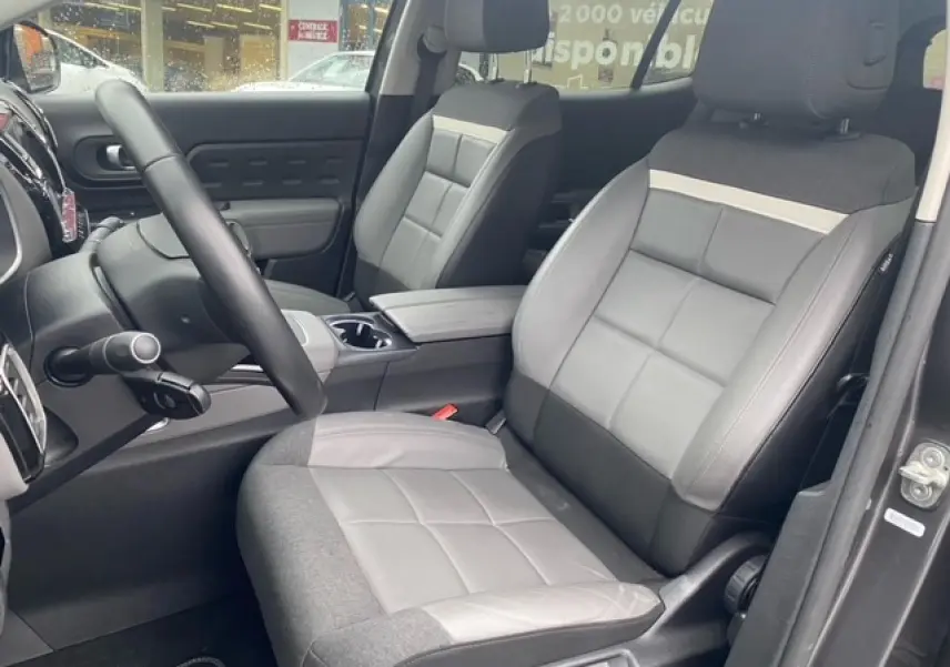 Vue intérieure côté conducteur du Citroën C5 Aircross 2019, sièges bi-matière gris et console centrale visible.