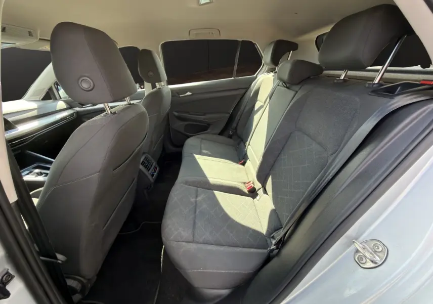 Vue intérieure côté droit des sièges arrière gris foncé de la Volkswagen Golf 2022 avec banquette 3 places et appuie-têtes.