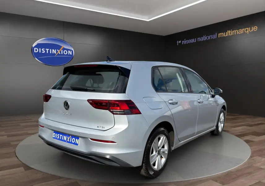 Vue 3/4 arrière droite d'une Volkswagen Golf gris clair 2022 avec feux LED et badge eTSI visible.