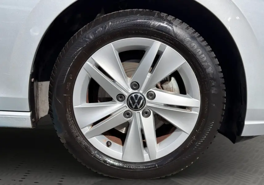 Gros plan sur la roue avant droite grise d'une Volkswagen Golf 2022 avec jante alliage et logo VW central.