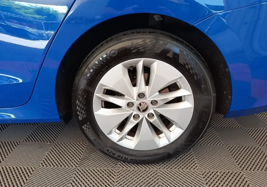 Gros plan sur la roue avant droite d’une Skoda Octavia bleue 2024 avec jante argentée et pneus Kumho.