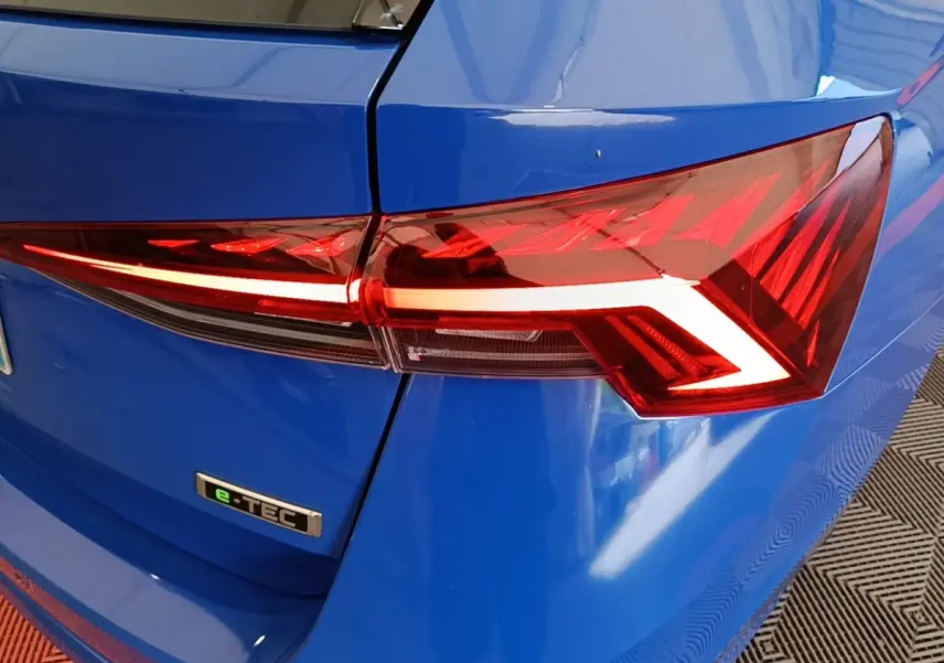 Gros plan sur le feu arrière droit rouge et le logo e-TEC d'une Skoda Octavia bleue 2024 vue de l'arrière.