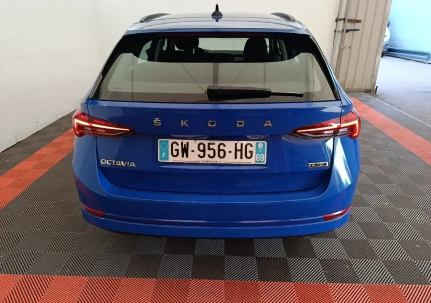 Vue arrière d'une ŠKODA Octavia bleue avec feux LED allumés et plaque d'immatriculation française visible.