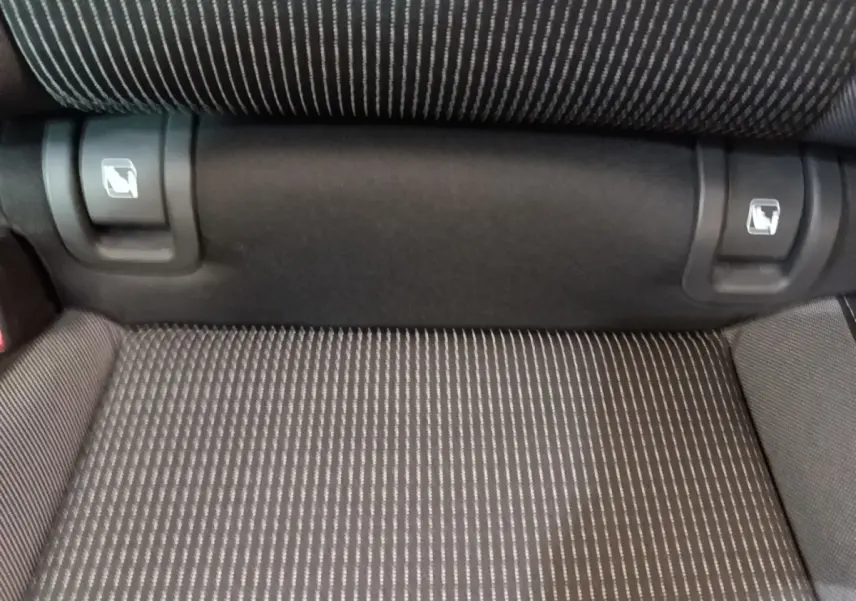 Détail de la banquette arrière grise à motifs rayés avec commandes de rabattement visibles, Skoda Octavia 2024.