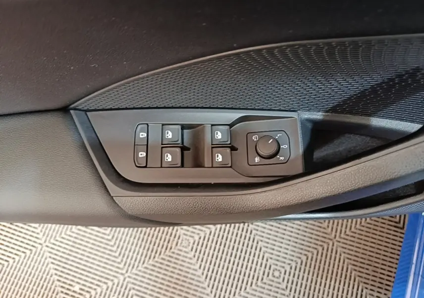 Commande des vitres et réglage des rétroviseurs sur la porte côté conducteur d'une Skoda Octavia bleue.