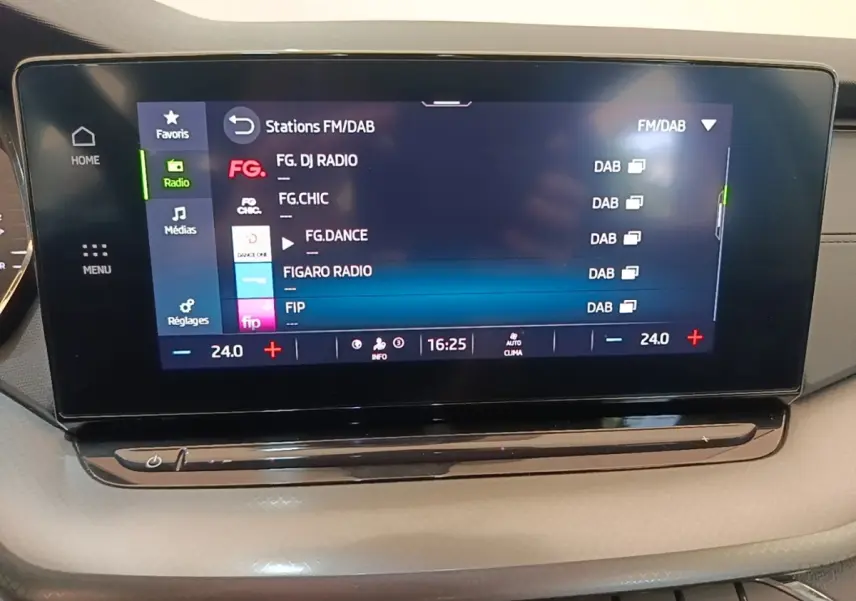 Écran tactile central de la Skoda Octavia 2024 affichant les stations radio FM/DAB, avec commandes climatisation en dessous.