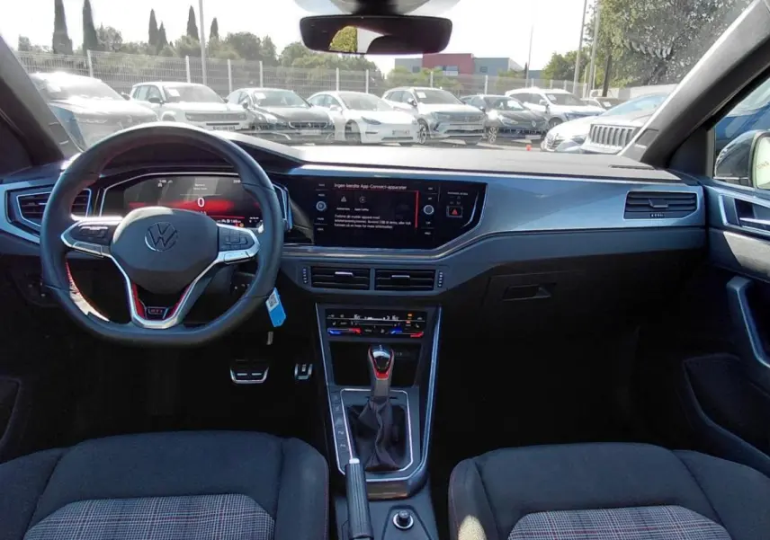 Vue intérieure avant de la Volkswagen Polo GTI 2024 noire, avec volant sport, cockpit numérique et console centrale moderne.