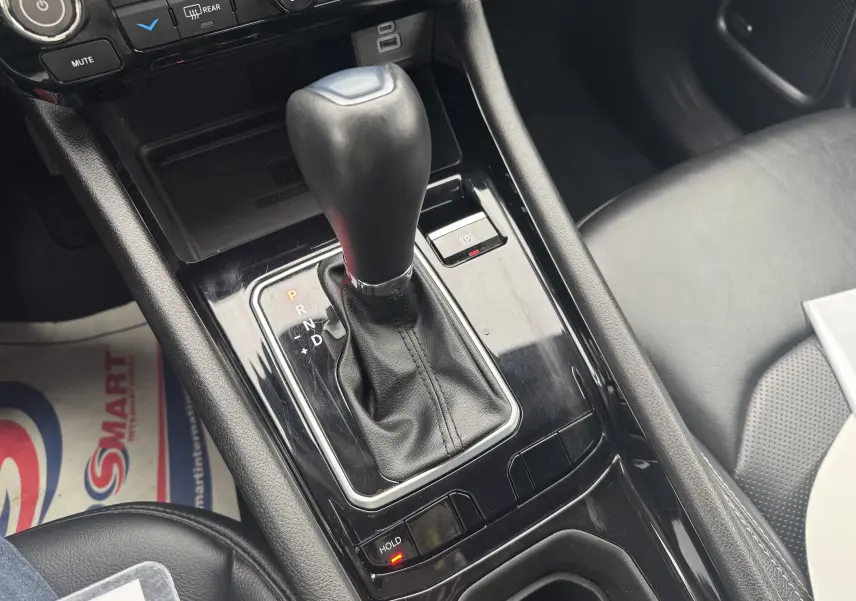 Le levier de vitesse automatique noir du Jeep Compass 2023 essence hybride, vu en gros plan dans la console centrale.