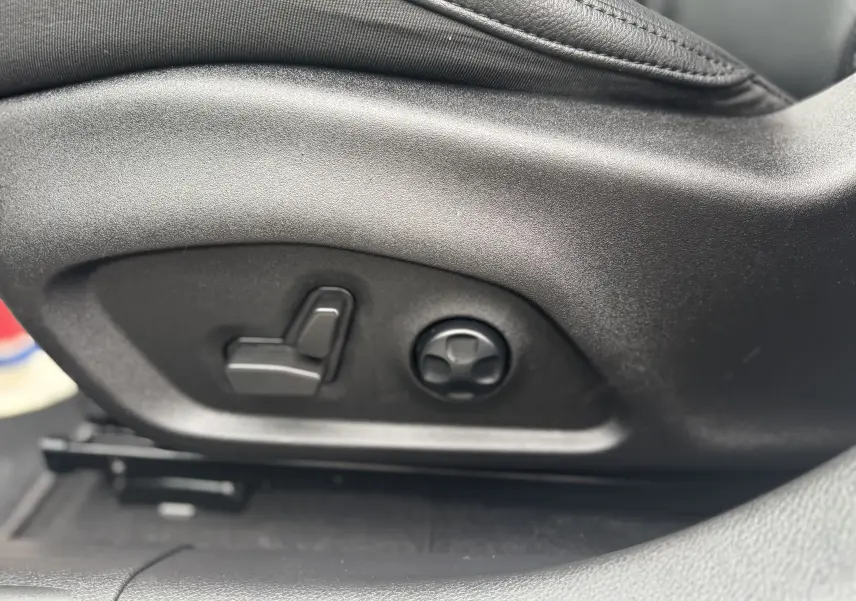 Gros plan sur les commandes de réglage électrique du siège avant en cuir noir du Jeep Compass gris 2023.