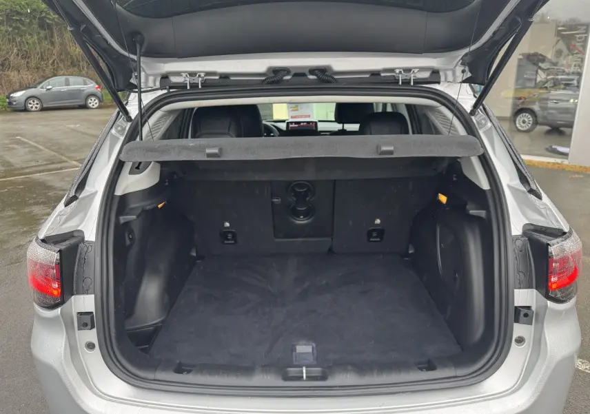 Coffre ouvert d'un Jeep Compass gris 2023, vue arrière montrant l'espace de chargement et la plage arrière relevée.