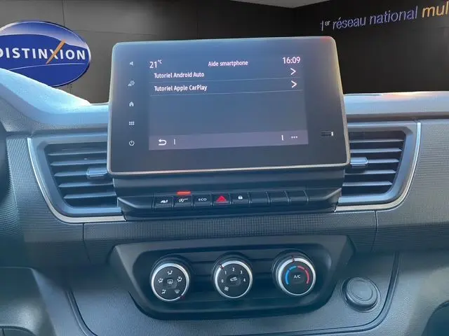 Vue rapprochée du tableau de bord du Renault Trafic Fourgon blanc 2023, avec écran tactile et commandes climatisation.