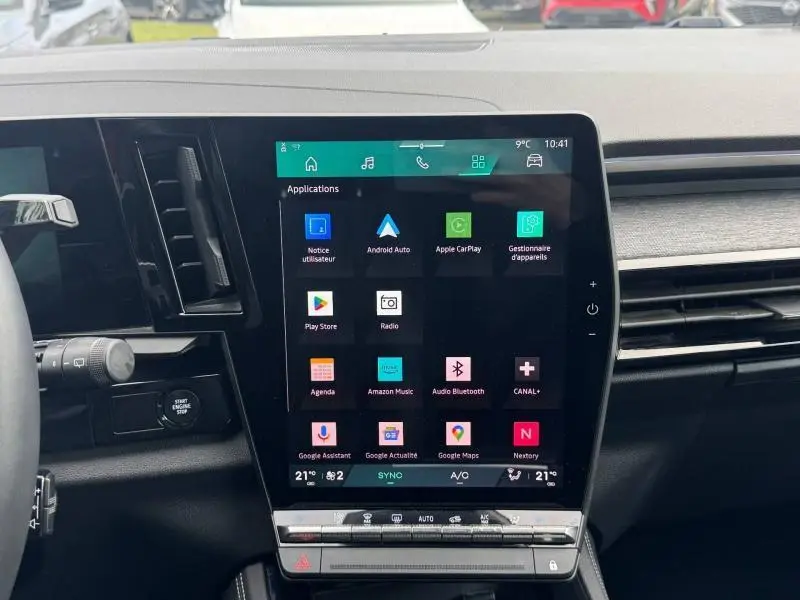 Vue rapprochée de l’écran tactile central du tableau de bord du Renault Austral rouge, affichant les applications connectées.