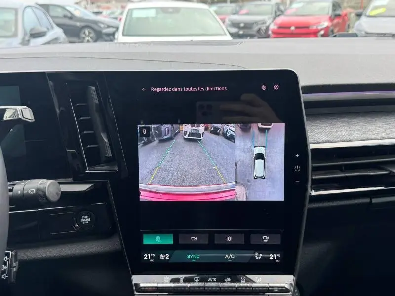 Écran tactile intérieur montrant la caméra de recul et vue 360° du Renault Austral rouge Flamme, tableau de bord moderne.