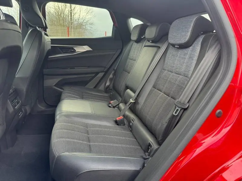 Vue intérieure côté droit sur la banquette arrière en tissu gris clair du Renault Austral rouge flamme 2025.