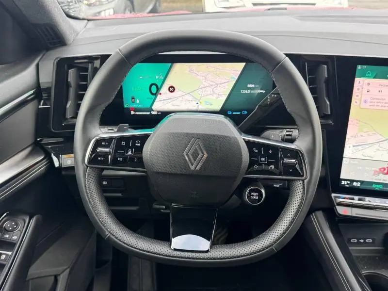 Vue intérieure centrée sur le volant noir du Renault Austral avec écran numérique et tableau de bord moderne.