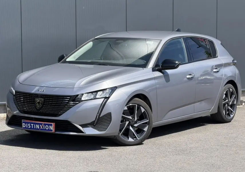Peugeot 308 Hybrid gris Artense vue 3/4 avant droit, avec jantes alliage et signature lumineuse LED distinctive.