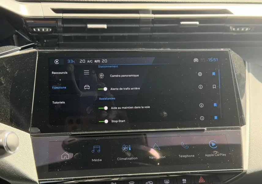 Écran tactile central de la Peugeot 308 Hybrid 145 gris Artense montrant les aides à la conduite et Apple CarPlay.