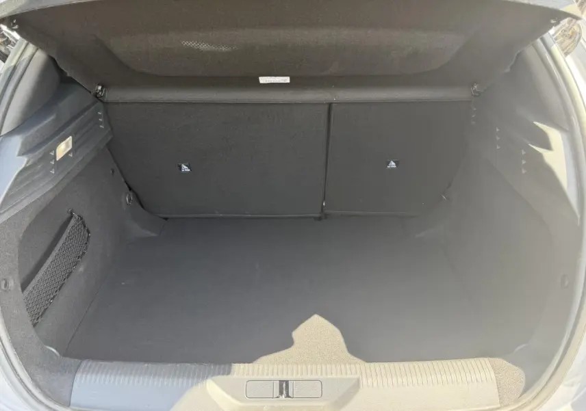 Coffre ouvert de la Peugeot 308 Hybrid 145 gris Artense, vue arrière montrant l'espace de rangement vide.
