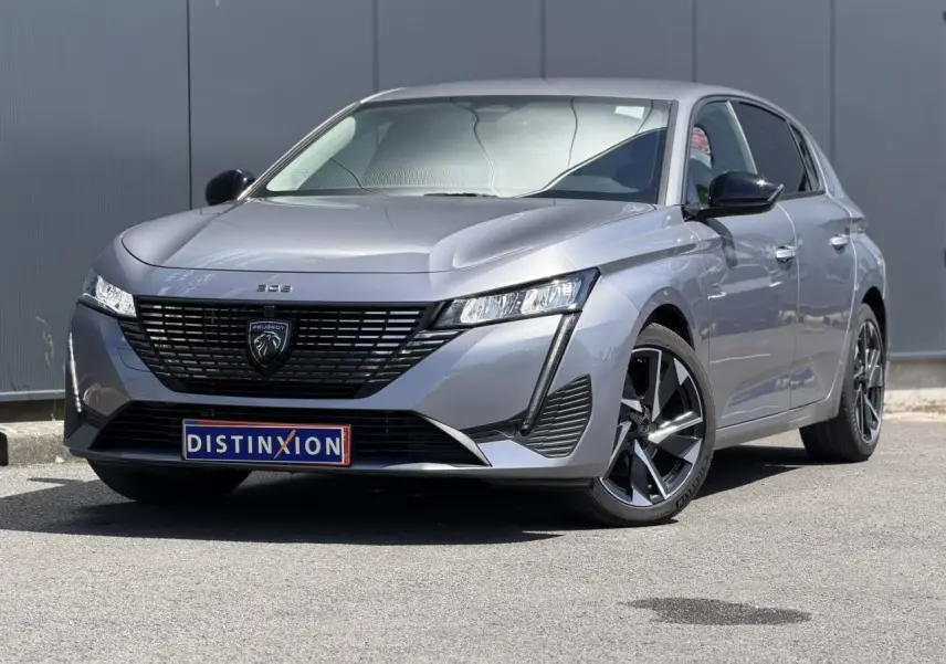 Peugeot 308 Hybrid gris Artense vue 3/4 avant droit, avec calandre noire et jantes alliage 17 pouces.