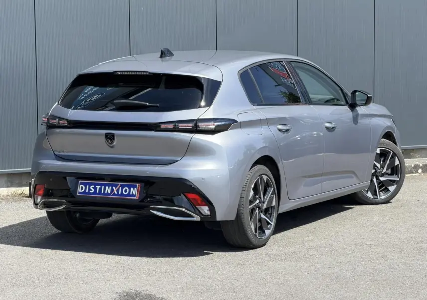 Peugeot 308 Hybrid 145 gris Artense vue 3/4 arrière droit, jantes alliage et feux arrière LED distinctifs.