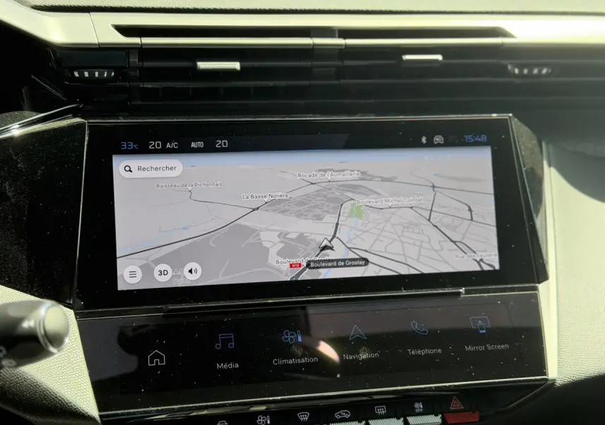 Vue rapprochée de l’écran tactile central du Peugeot 308 Hybrid 145 gris Artense, affichant la navigation connectée.