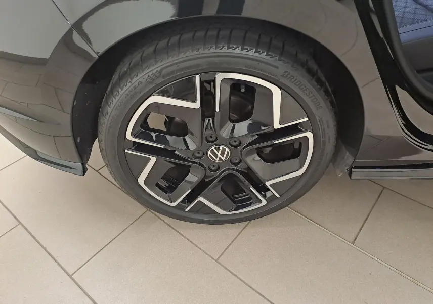 Gros plan sur la jante alliage 18'' York noire et argentée du côté arrière droit d'une Volkswagen Golf noire Grenadille.