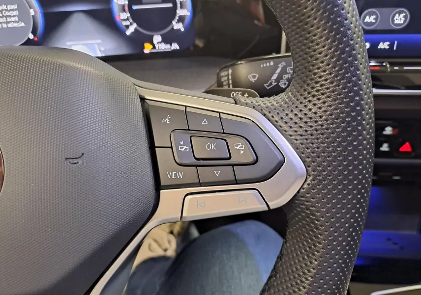 Gros plan sur les commandes au volant en cuir perforé noir de la Volkswagen Golf 2.0 TDI 150 DSG7 R Line 2024.