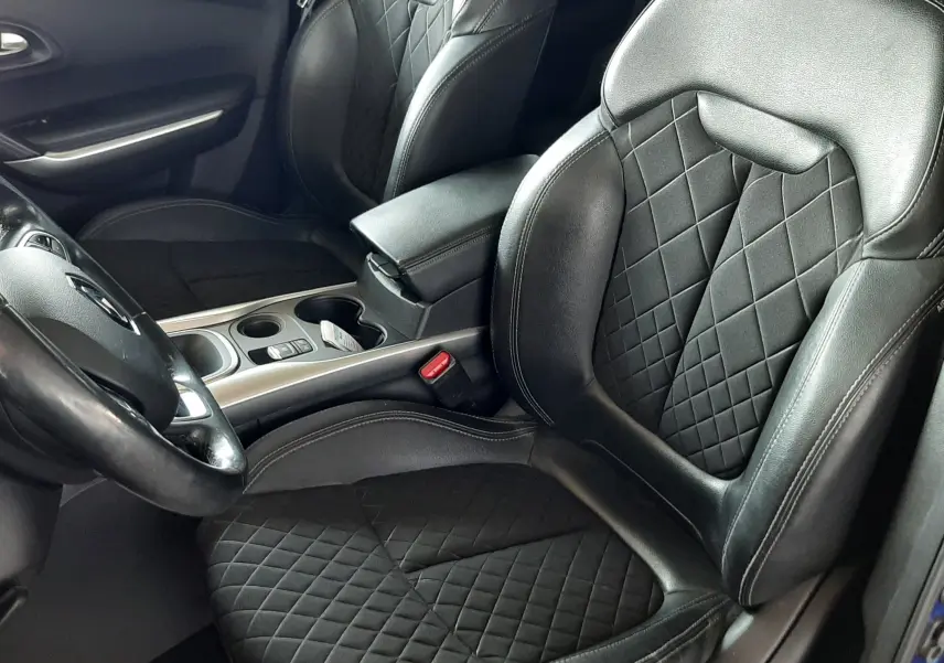 Vue intérieure côté conducteur du Renault Kadjar 2020 bleu iron, sièges noirs en cuir et tissu matelassé avec console centrale visible.