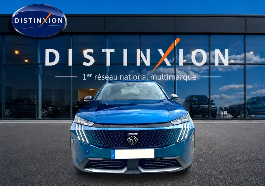 Vue frontale d'un Peugeot 3008 2025 bleu obsession avec calandre distinctive et phares LED verticaux allumés.